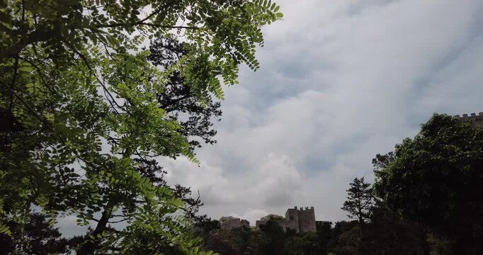 Tilt Down Shot Revealing Castello di Venere and Torrette del Balio Framed by Foliage, Erice, Italy