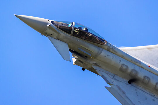 Close up of a fighter jet nose and cockpit against blue sky