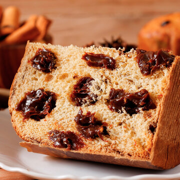 Sliced ​​Italian panettone with creamy chocolate filling served during a Christmas celebration.