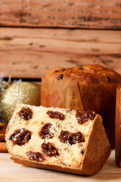Sliced ​​Christmas panettone with creamy chocolate on a rustic wooden table during a family celebration.