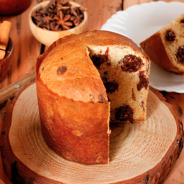 Sliced ​​chocolate panettone served as a special dessert on a rustic wooden table.