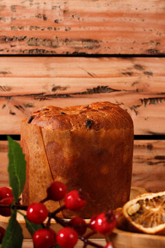 Homemade Christmas panettone with creamy chocolate, sliced ​​on an ornate rustic wooden table.