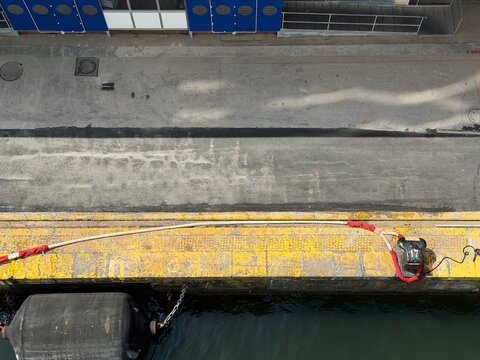 Heavy cruise ship hawsers still lie slack and unfastened on the quay, waiting to be properly secured by the port workers
