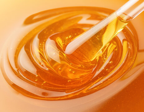 Extreme Macro of Viscous Golden Honey Swirled with Glass Wand
