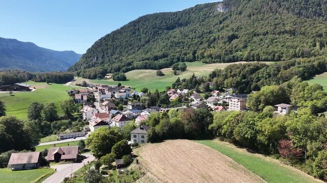 Sunlit village nestled among rolling green hills