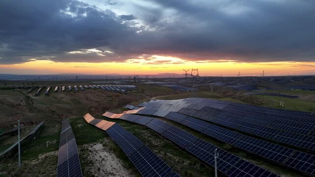 solar power plant at sunset with panels on hillside