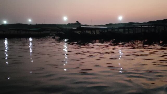 Calm ocean waves reflecting sunset light with gentle boat movement at dusk