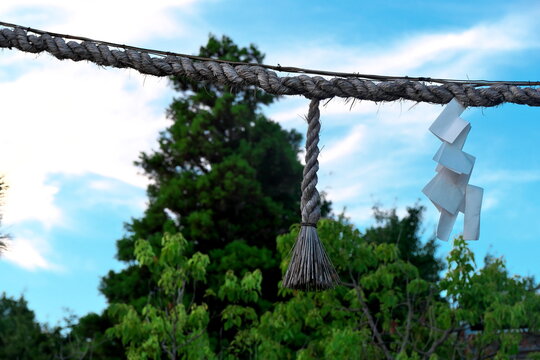 Shimenawa rope with shide against blue sky in Japan