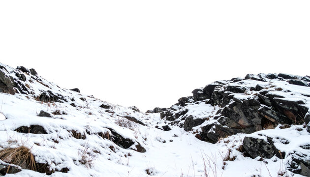 Snowy rocky landscape featuring jagged mountain stones covered in fresh winter powder with dry grass patches&nbsp;