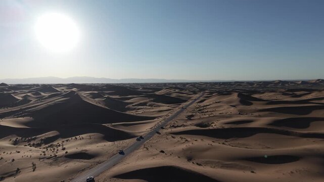 Aerial view of desert dunes with road and vehicles in Tengger Desert