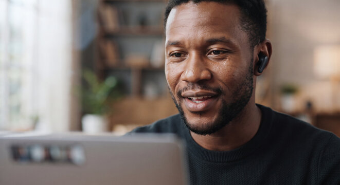 Smiling Man Participating In Online Video Conference From Home Office With Laptop
