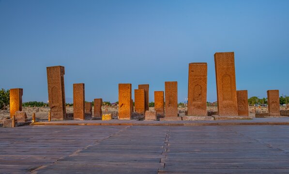 Row of historical Seljuk tombstones illuminated under the blue hour sky after sunset in the ancient Ahlat Seljuk Cemetery, Bitlis, Turkey. Long exposure shot highlighting medieval Islamic funeral arch
