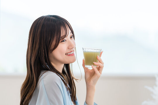 Young Woman Enjoying a Nutritious Green Smoothie, Healthy Morning Routine for Beauty and Wellness