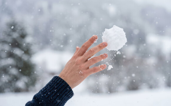 Man throwing a snowball in winter outdoors, representing fun outdoor activities and winter season joy
