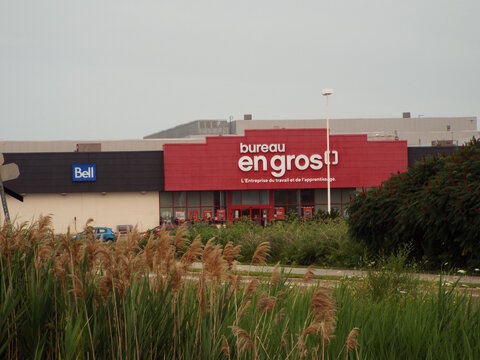 Gatineau, Quebec, Canada &ndash; July 07, 2026: An outdoor view showing the storefront exterior and bilingual signage of a "Bureau en Gros" store with a Bell section on Mnt Paiement.