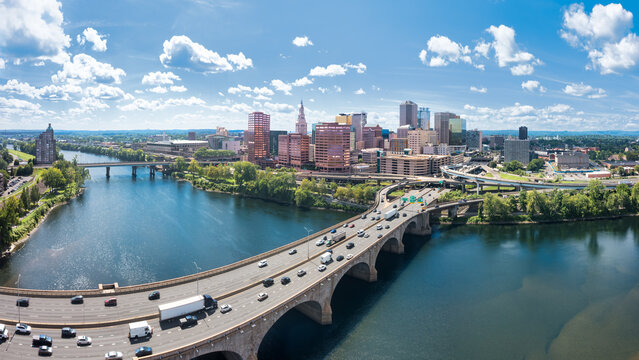 Hartford skyline panorama from across the Connecticut River, above Bulkeley I84 bridge, showcasing downtown buildings, the waterfront, and the capital of Connecticut.