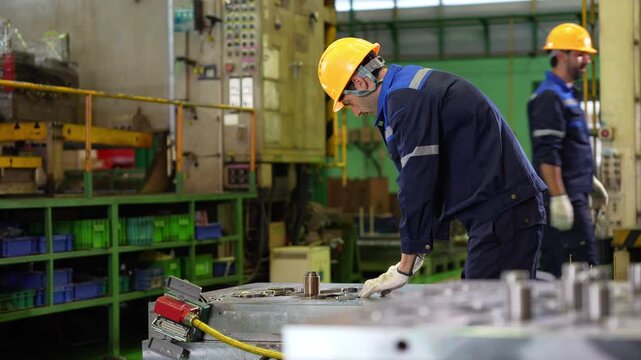 Factory worker man inspecting metal mold in manufacturing plant, Professional mechanic working on production equipment in plant, Technician operating industrial machinery in factory workshop