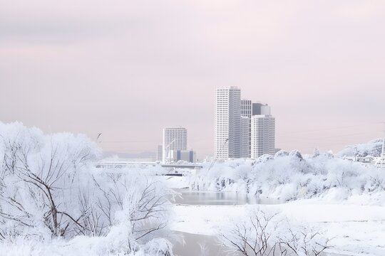 Snow covered Tama river bed and Futakotamagawa skyline in winter Tokyo Japan