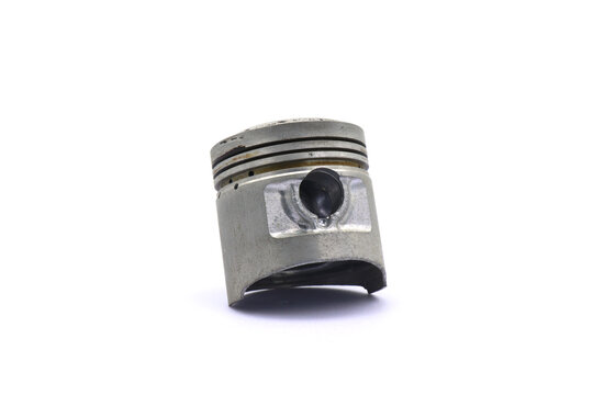 A piston from a 4 stroke motorcycle engine on a white background.