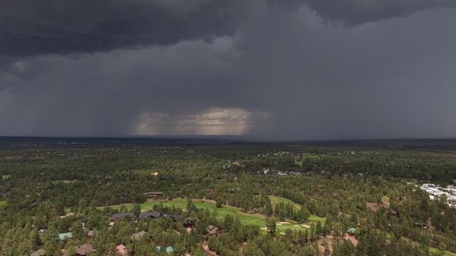 Dramatic aerial view of an afternoon thunderstorm approaching a golf course community in Show Low, Arizona, as a safety warning horn sounds to alert golfers to dangerous lightning conditions.