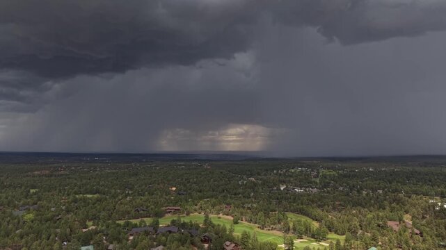 Dramatic aerial view of an afternoon thunderstorm approaching a golf course community in Show Low, Arizona, as a safety warning horn sounds to alert golfers to dangerous lightning conditions.