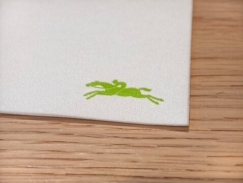 Shanghai,China-Dec.13th 2025: iconic green galloping horse logo of Longchamp on paper