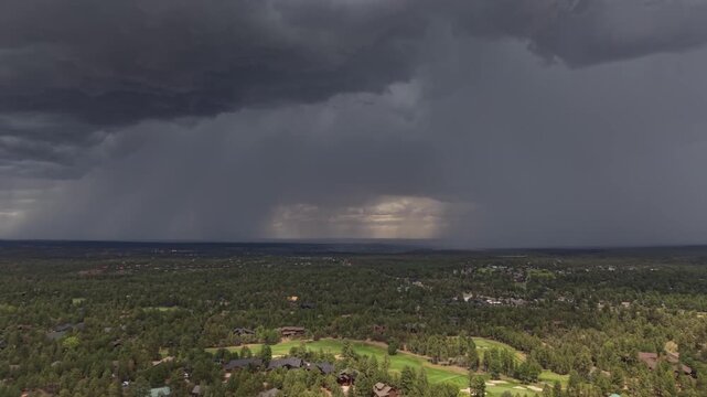 Dramatic aerial view of an afternoon thunderstorm approaching a golf course community in Show Low, Arizona, as a safety warning horn sounds to alert golfers to dangerous lightning conditions.