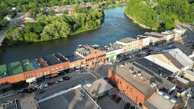 Aerial drone shot over historic downtown Paris along Grand River Street, approaching the Grand River as it winds through Paris, Ontario, Canada on a warm sunny summer afternoon.