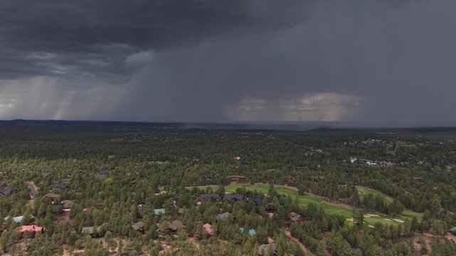 Dramatic aerial view of an afternoon thunderstorm approaching a golf course community in Show Low, Arizona, as a safety warning horn sounds to alert golfers to dangerous lightning conditions.