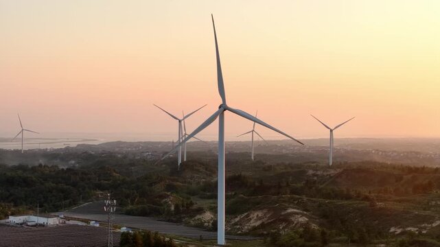 wind turbines standing on hills during sunset