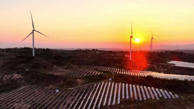 Wind turbines and solar panels on a hillside forming a clean energy base