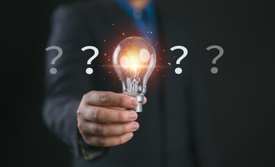 Problem solving and idea concept with glowing light bulb selected among question marks, representing decision making, innovation, creative thinking, solution finding and focus on the right answer © Nirusmee