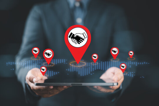 Business partnership concept showing global deal and agreement with handshake icons on world map for symbol of international collaboration, corporate networking, strategic alliance trust and success.
