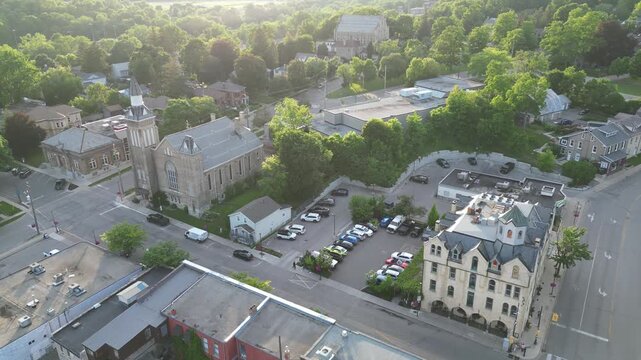 Aerial drone shot flying away from historic downtown Paris, approaching several old churches and neighborhoods. Located in Paris, Ontario, Canada on a warm sunny summer afternoon with lots of sunlight