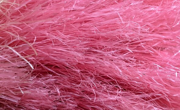​Close-up texture of bright pink plastic broom fibers