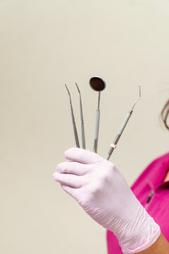 Dental professional holding instruments for oral examination