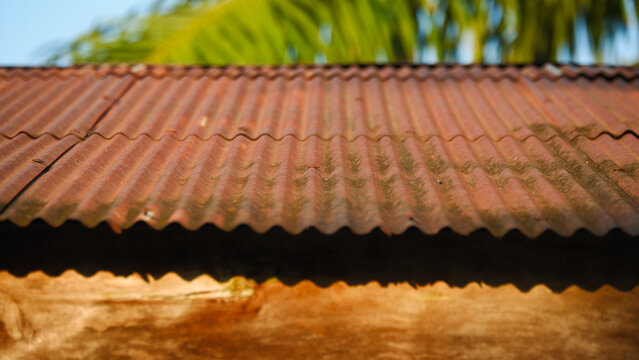Old rusty corrugated iron roof on tropical house background