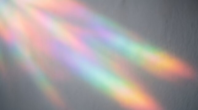 Abstract background featuring soft rainbow light leaks and colorful prism flares on a dark grey surface