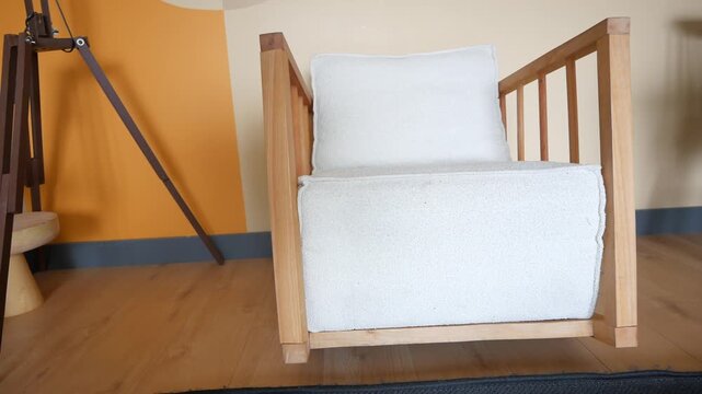 Minimalist wooden armchair with white boucle upholstery in sunlit modern interior