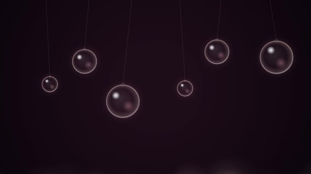 Shiny glass spheres hanging on thin strings against a dark purple background representing balance and physics concepts for business and science presentation design 4k Motion Video