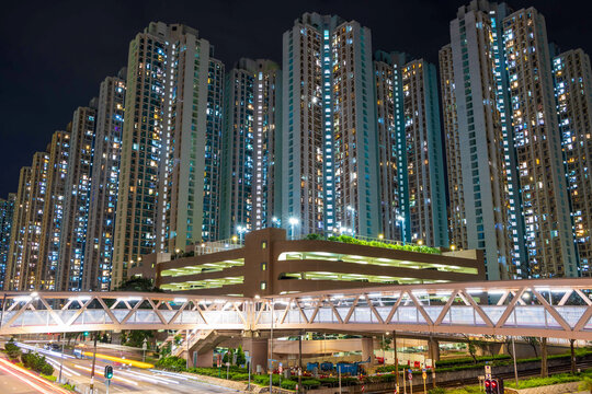 High-density public housing estate towers and pedestrian footbridge at night, Hong Kong