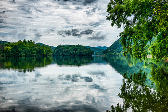 Calm lake water reflecting trees and clouds near the Tail of the Dragon North Carolina