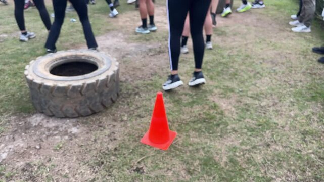 People exercising outdoors with tire and cone fitness training