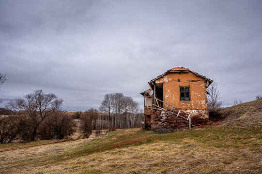 Old abandoned rural mud house on a hillside under cloudy autumn sky, Bulgaria