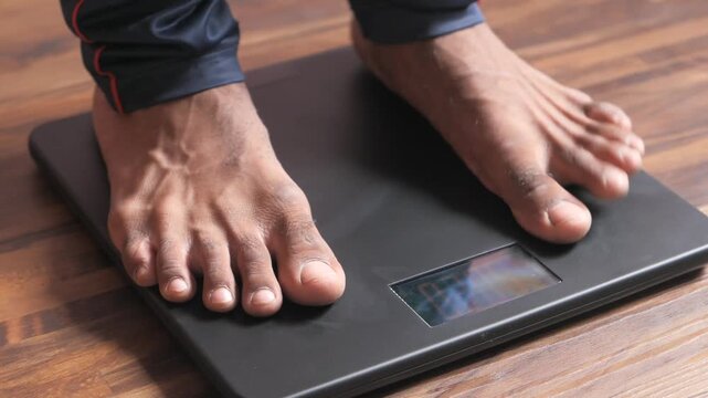 Person stepping on digital scale to measure weight