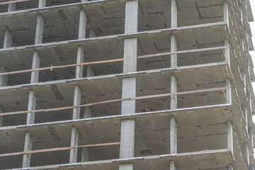Construction progress on a tall building with concrete structure and scaffolding in the city during daylight © beholdereye