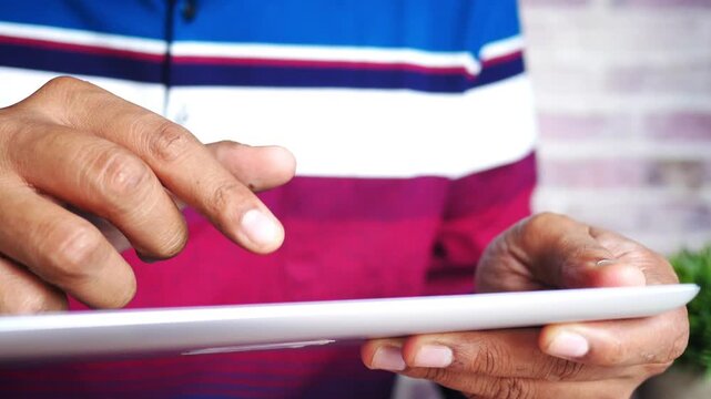 Close-up slow motion footage of a person's hands skillfully operating a tablet device, highlighting the precision and ease of modern touch-screen technology