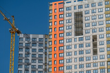 Fototapeta premium New apartment complex under construction showcasing modern architecture and vibrant colors in a bustling urban setting