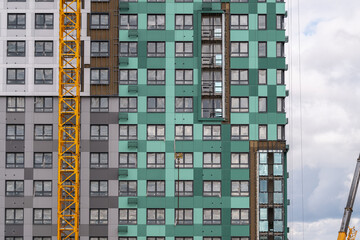 Construction progresses on a modern high-rise building featuring vibrant colors and innovative design elements © beholdereye