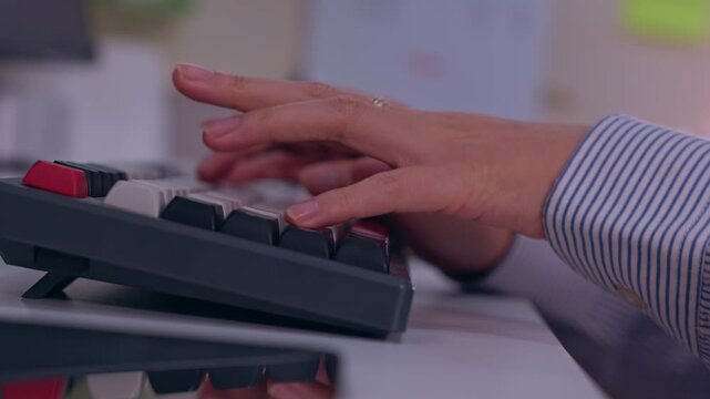 Typing hand computer keyboard office desk, striped sleeve and jewelry visible during focused work, digital communication, professional productivity, close up indoor workspace with mechanical keyboard